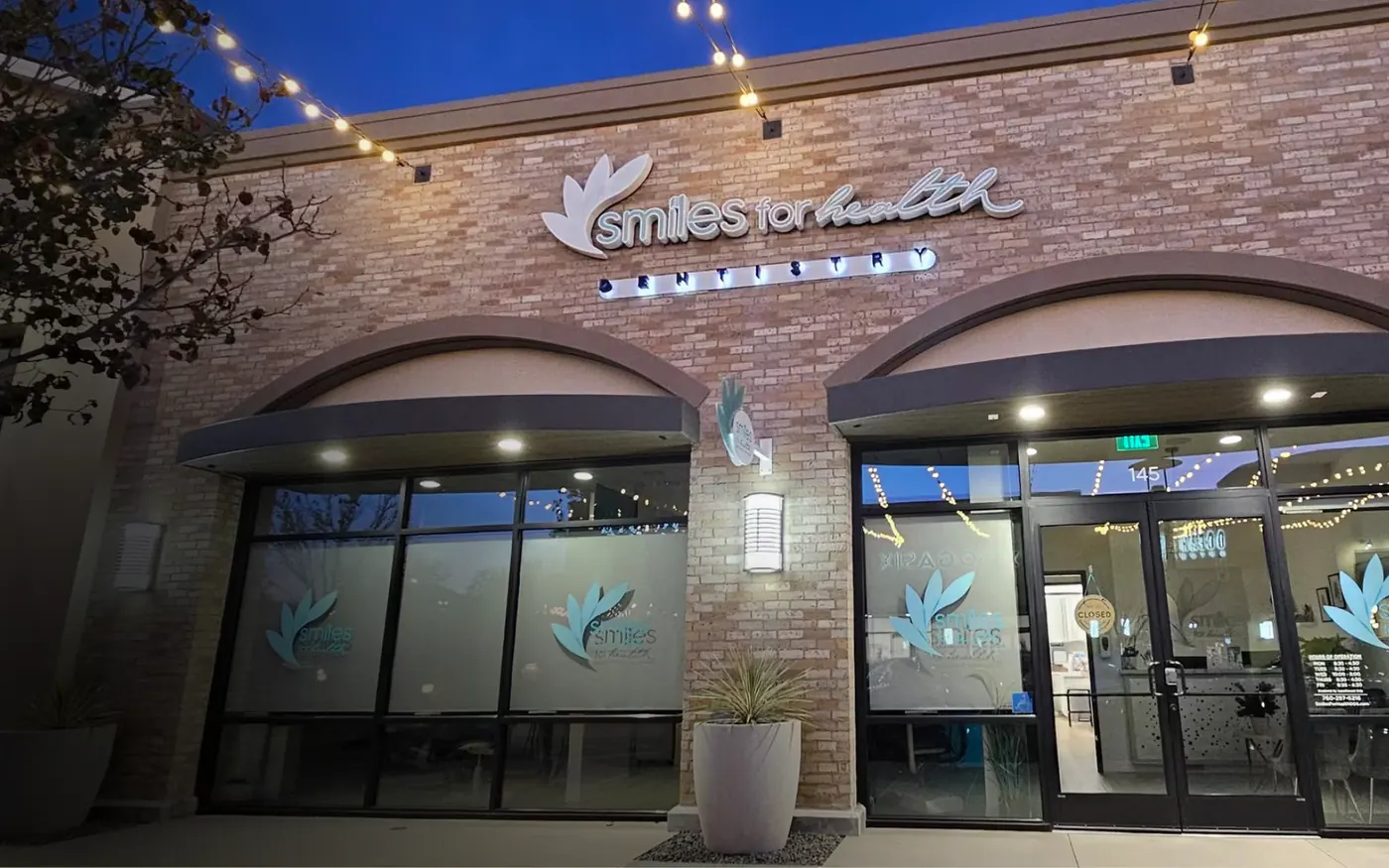 The Smiles for Health storefront on Gateway Road, lit at dusk